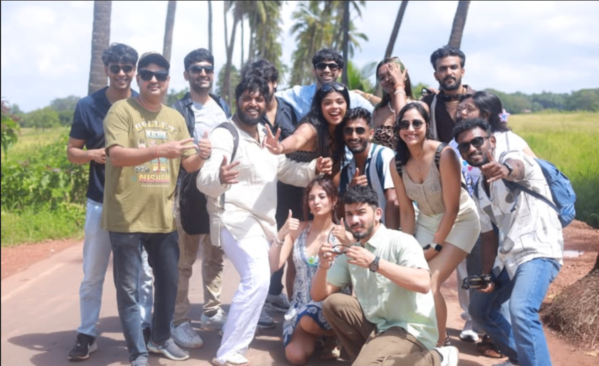 Large Roava group posing on a palm-lined road in Goa