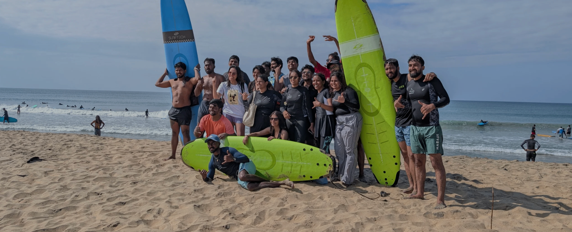 Roava group together on the beach with surfboards