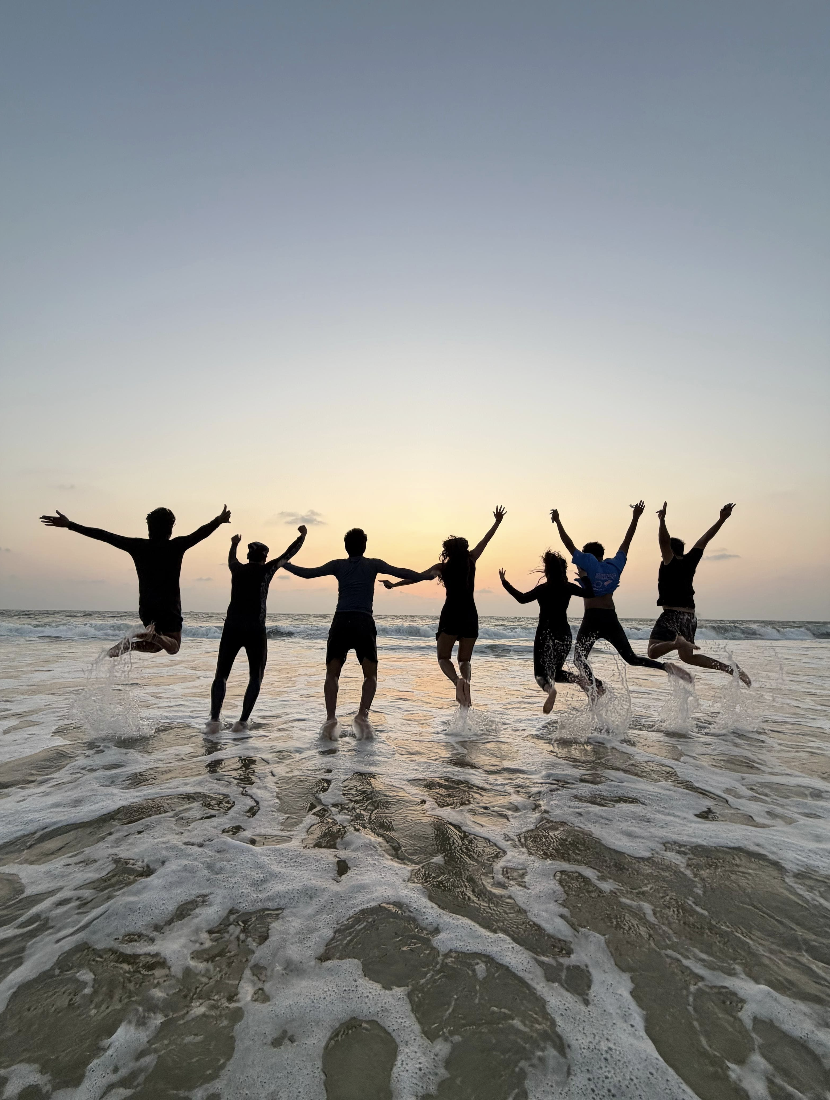 Friends jumping at sunset on the beach